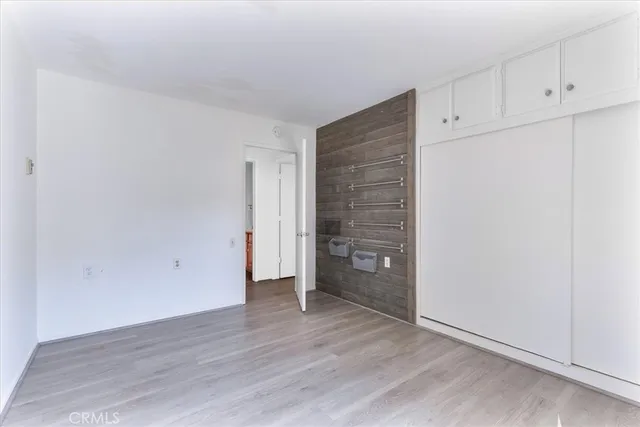 an empty room with wooden floor and cabinet