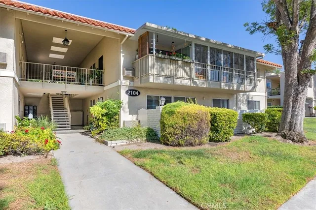 a view of a house with brick walls and a yard with potted plants