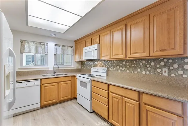 a kitchen with stainless steel appliances granite countertop a sink and cabinets with wooden floors