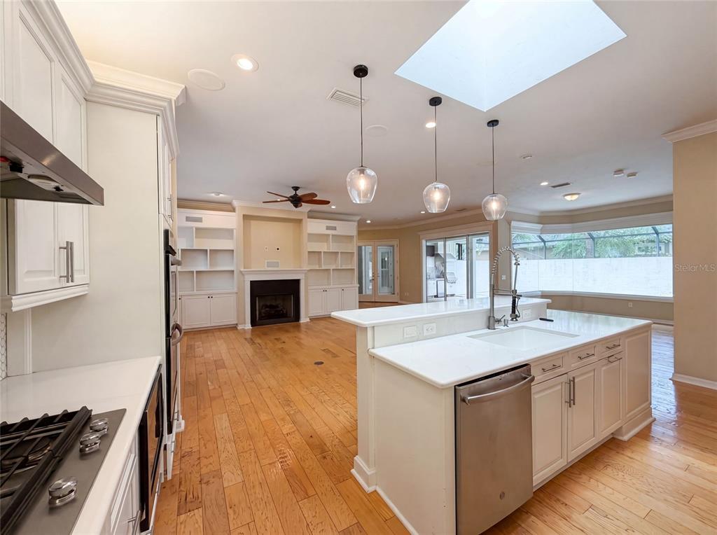 13478 Northwest 9 Road Newberry, FL 32669 - Photo 9 of 31 a large kitchen with kitchen island a stove a sink a center island and wooden floor