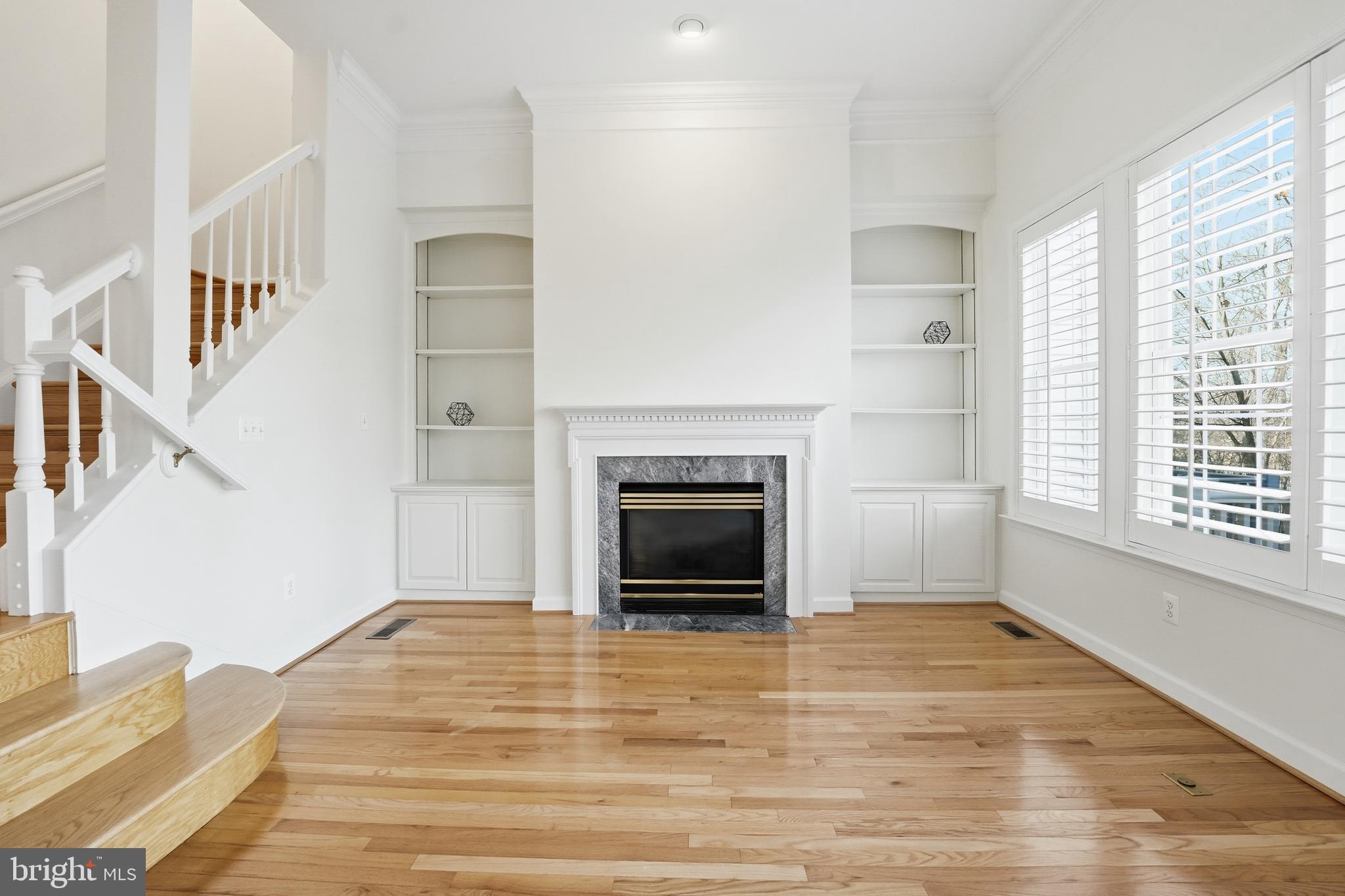 1919 Logan Manor Drive Reston, VA 20190 - Photo 16 of 54 a view of an empty room with wooden floor fireplace and a window