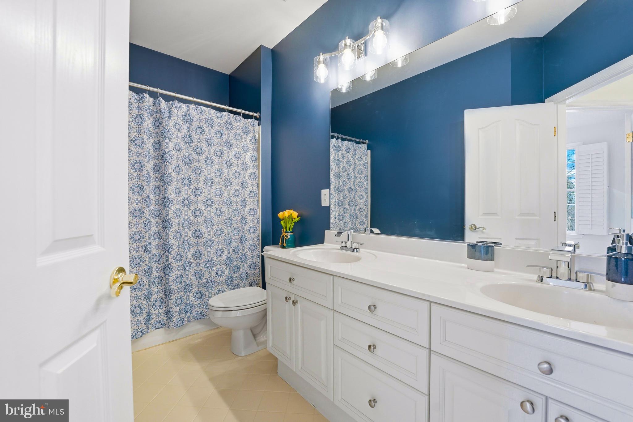 1919 Logan Manor Drive Reston, VA 20190 - Photo 34 of 54 a bathroom with a granite countertop sink a toilet a mirror and shower curtain