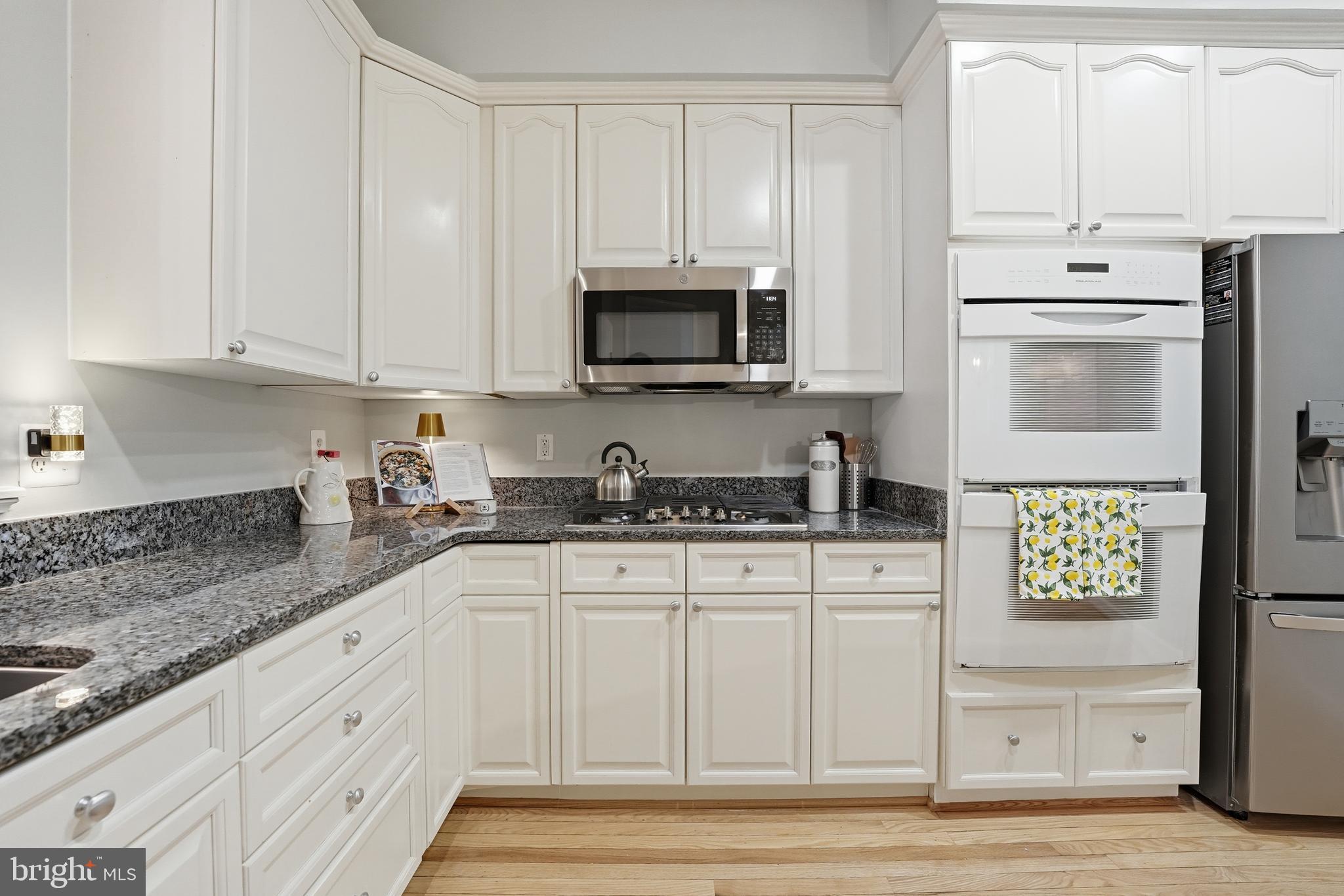 1919 Logan Manor Drive Reston, VA 20190 - Photo 9 of 54 a kitchen with granite countertop white cabinets and stainless steel appliances