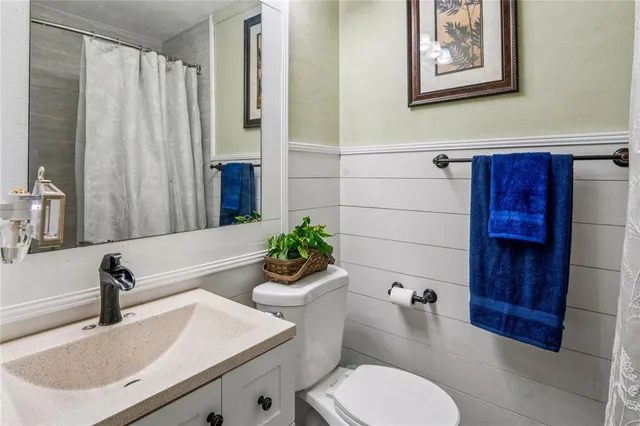 a bedroom with a bed a chandelier and flat screen tv