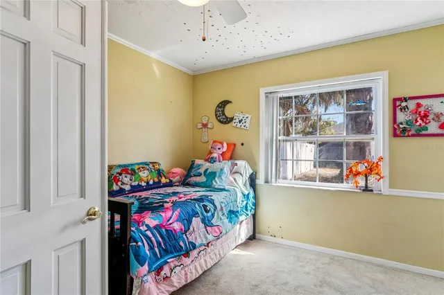 a bed sitting in a bedroom next to a window