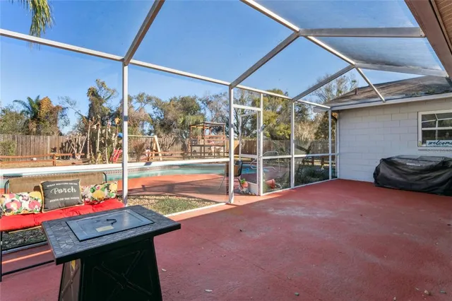 an aerial view of a house with swimming pool and large trees