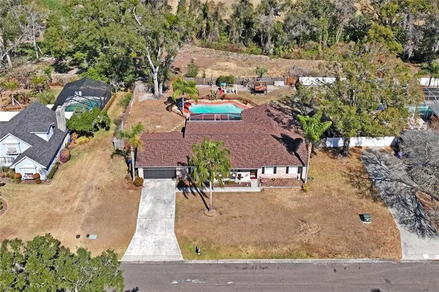 an aerial view of a house with yard swimming pool and lake view