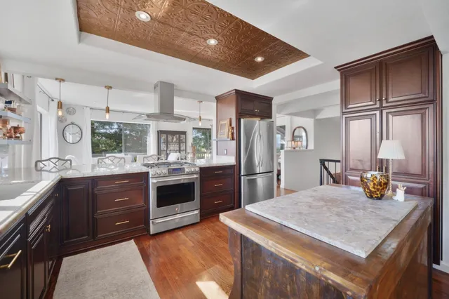 a kitchen with stainless steel appliances granite countertop a refrigerator a stove a sink and a refrigerator