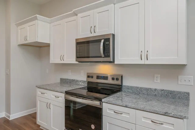 a kitchen with stainless steel appliances granite countertop white cabinets and a granite counter tops