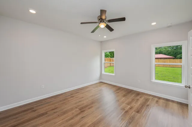 an empty room with a window and a ceiling fan