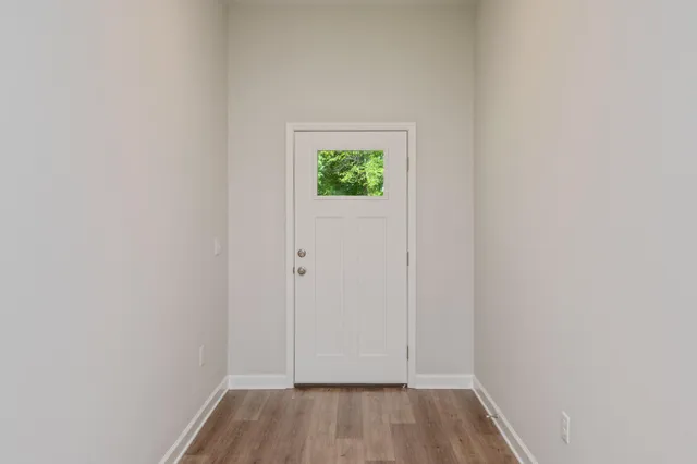 a view of a small space with wooden floor and a window