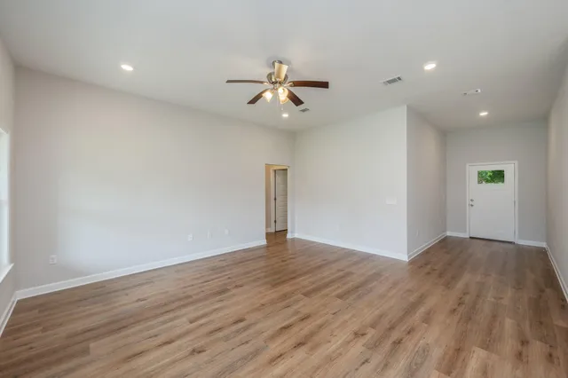 a view of empty room with wooden floor