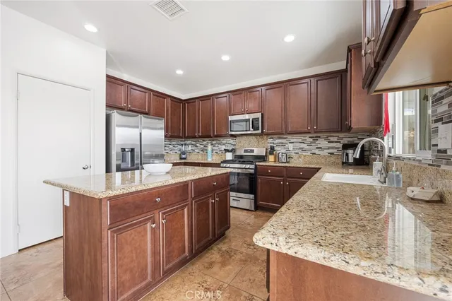 a kitchen with stainless steel appliances granite countertop a sink stove and cabinets