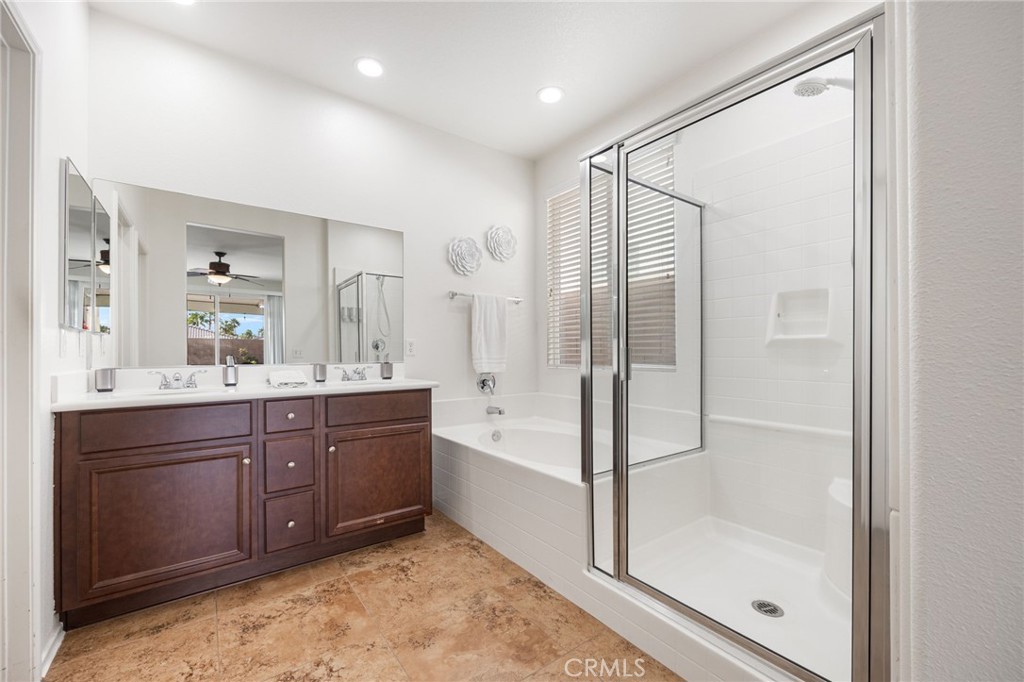 84155 Tramonto Way Indio, CA 92203 - Photo 35 of 38 a bathroom with a tub sink shower and mirror