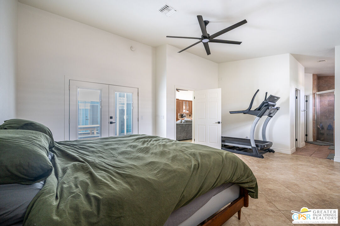 68210 Bella Vista Road Cathedral City, CA 92234 - Photo 18 of 47 a bedroom with a bed and a chandelier