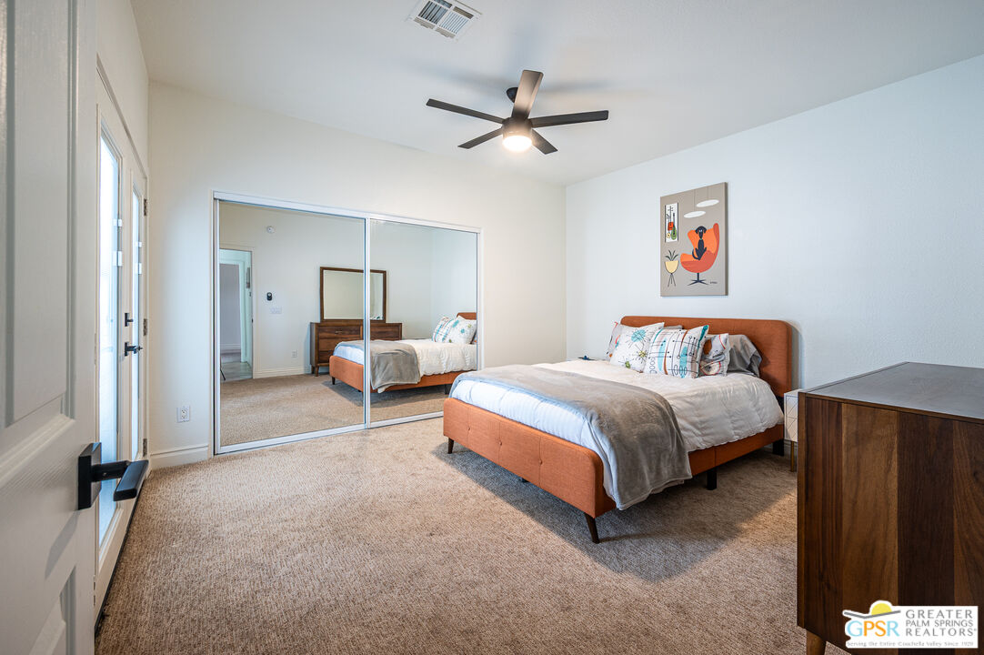 68210 Bella Vista Road Cathedral City, CA 92234 - Photo 21 of 47 a bedroom with a bed and a chandelier