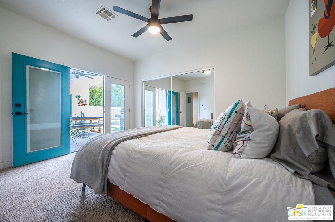 68210 Bella Vista Road Cathedral City, CA 92234 - Photo 22 of 47 a bed sitting in a bedroom next to a window and a chandelier
