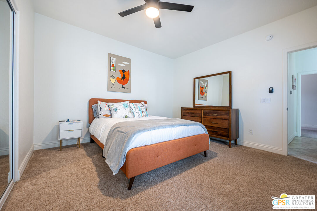 68210 Bella Vista Road Cathedral City, CA 92234 - Photo 23 of 47 a bedroom with a bed and a chandelier