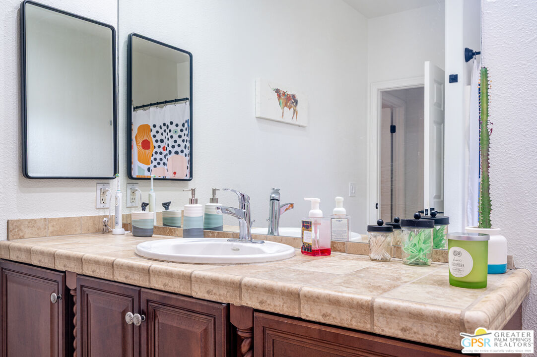 68210 Bella Vista Road Cathedral City, CA 92234 - Photo 25 of 47 a bathroom with a granite countertop double vanity sink and a mirror