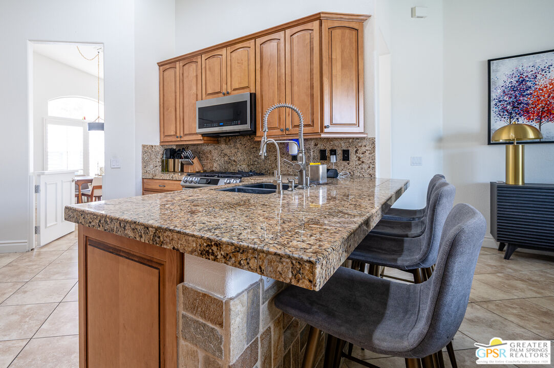 68210 Bella Vista Road Cathedral City, CA 92234 - Photo 7 of 47 a kitchen with a stove a sink and a microwave
