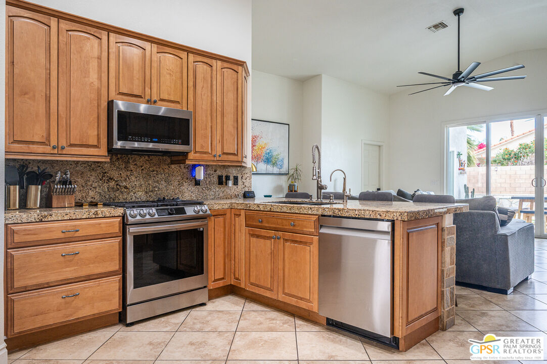 68210 Bella Vista Road Cathedral City, CA 92234 - Photo 9 of 47 a kitchen with stainless steel appliances granite countertop a stove a sink and a microwave