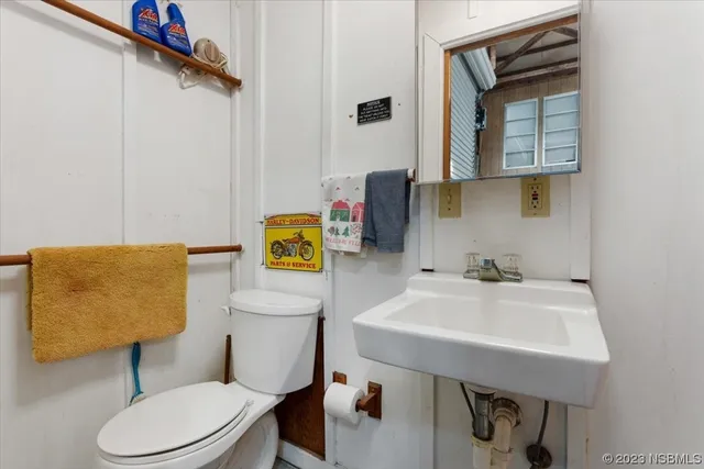 a bathroom with a sink a toilet and mirror