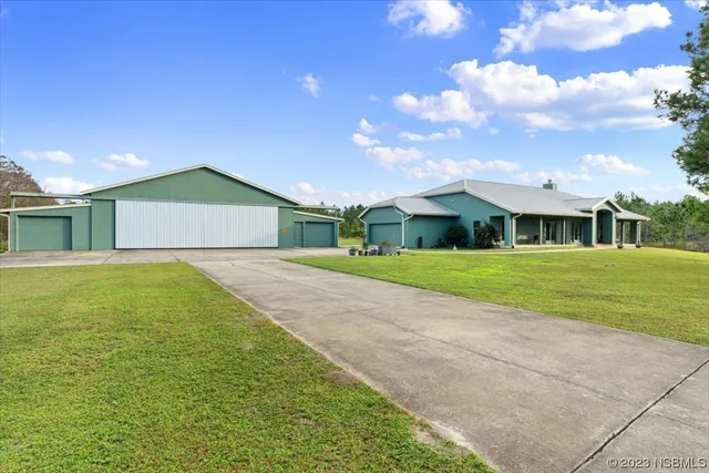 a view of an house with backyard and tree