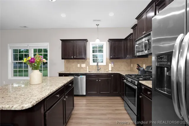 a kitchen with stainless steel appliances granite countertop a sink stove and refrigerator