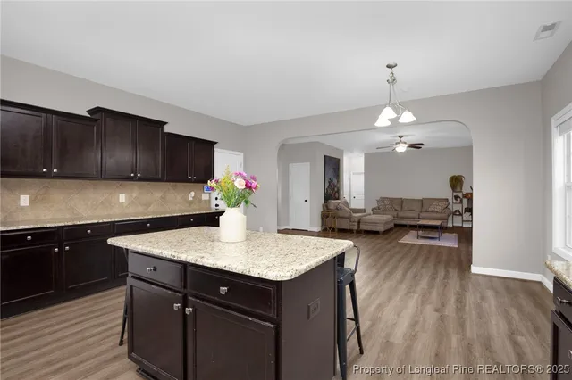 a kitchen that has a sink cabinets and wooden floor