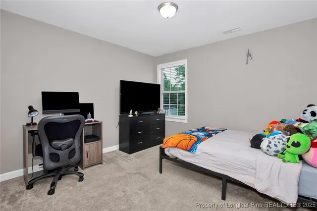 a bedroom with furniture and a flat screen tv