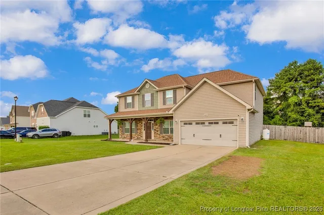 a view of a house with a big yard and large trees