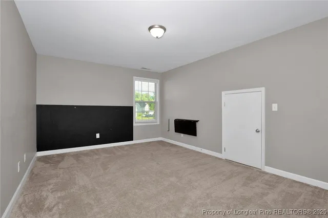 a view of an empty room with a fireplace and a window