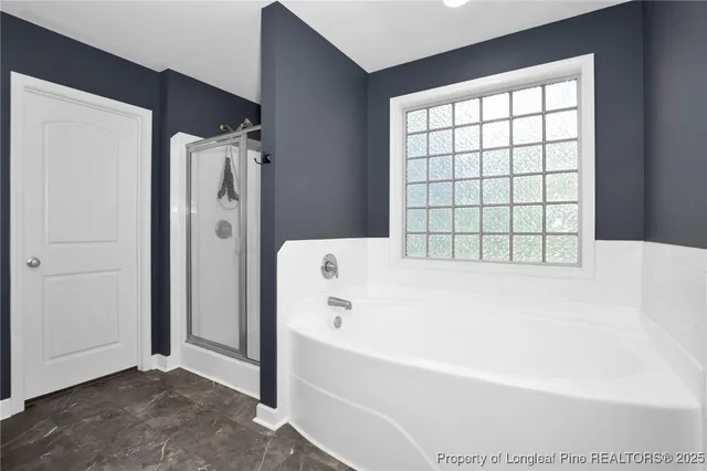 a bathroom with a bathtub and next to a window