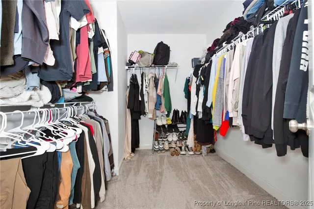 a view of walk in closet with clothes