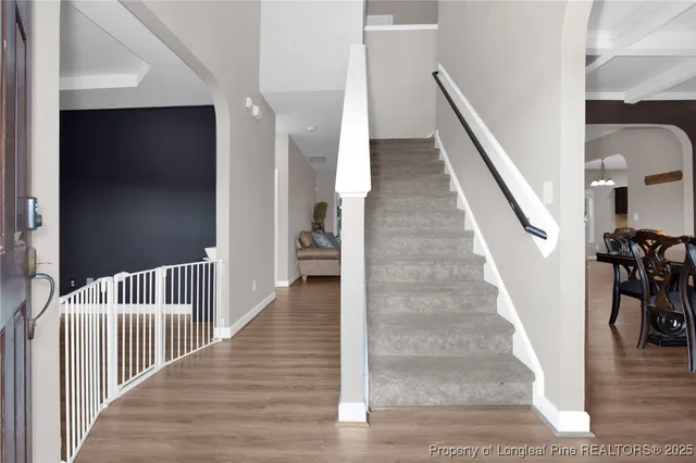 a view of a hallway with wooden floor and stairs