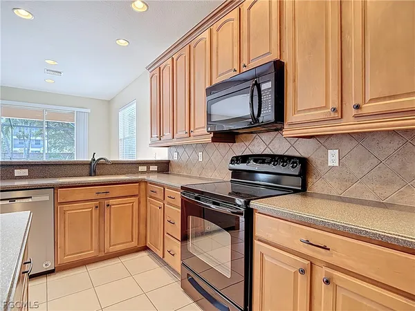 a kitchen with granite countertop a stove sink and cabinets