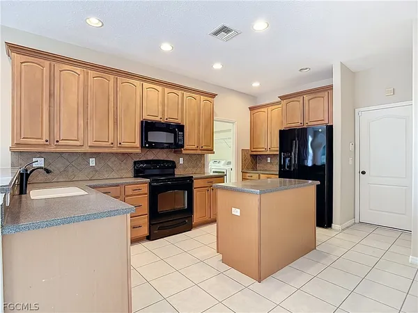 a kitchen with stainless steel appliances granite countertop a refrigerator stove microwave and sink