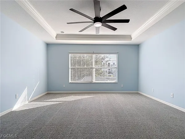 an empty room with a ceiling fan and windows