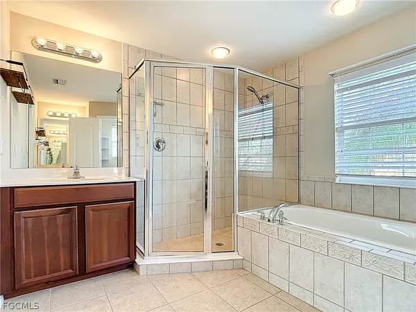 a bathroom with a tub sink shower and mirror