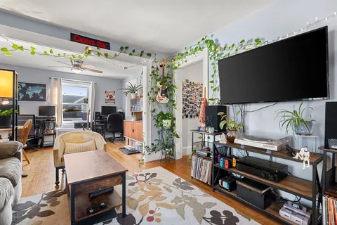a living room with furniture a dining table and a chandelier