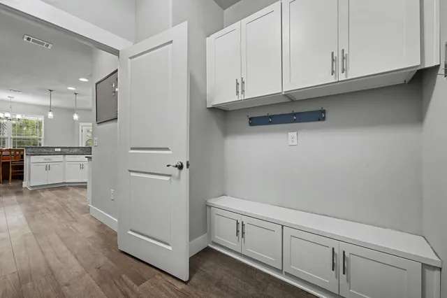a view of a kitchen with white cabinets and a wooden floor