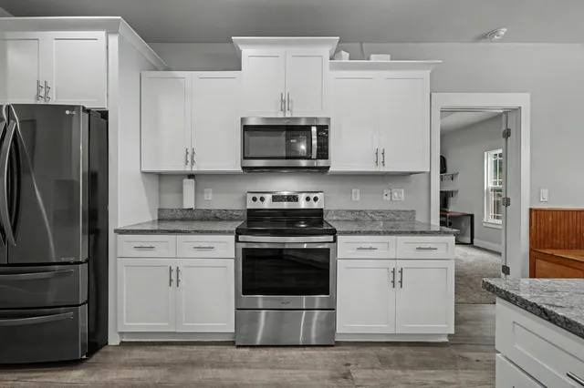 a kitchen with stainless steel appliances granite countertop a stove microwave and refrigerator