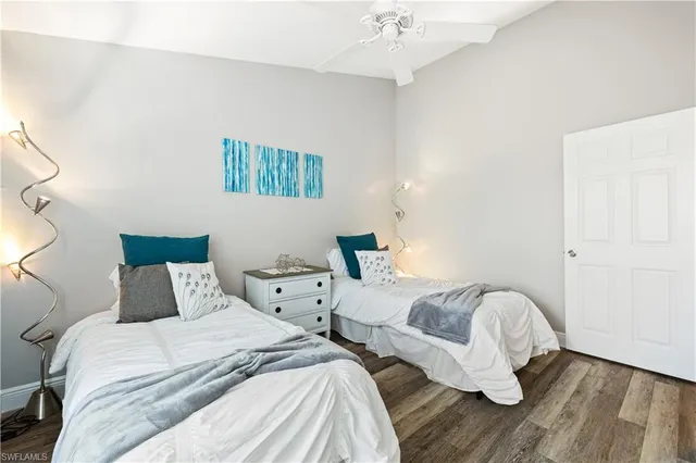 a bedroom with two beds and painting on the wall