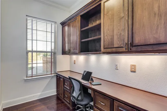 a view of a workspace with furniture and a window
