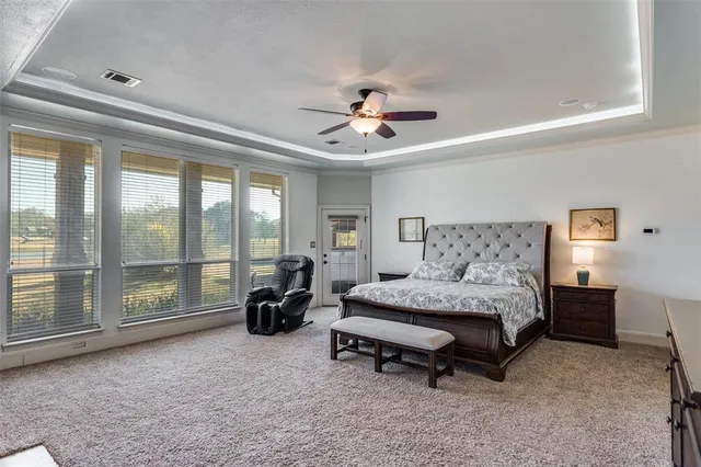 a spacious bedroom with a bed and a chandelier