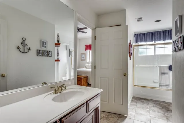 a bathroom with a sink vanity granite tub shower and a mirror