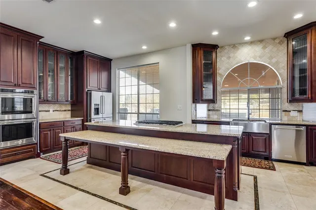 a large kitchen with kitchen island a sink a stove a dining table and chairs