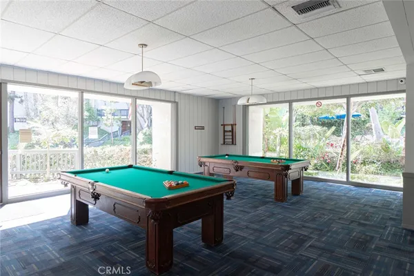 a room with pool table and windows