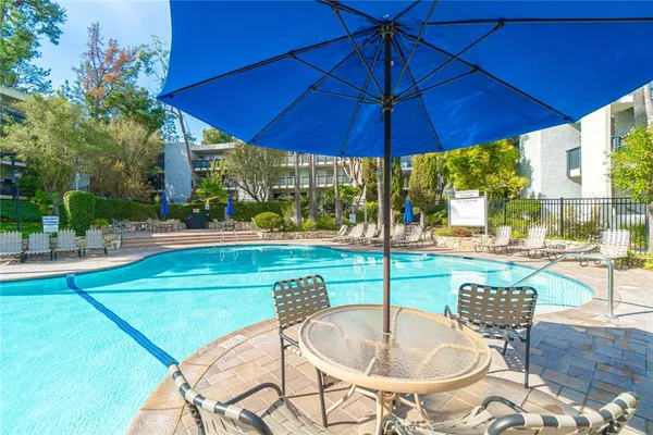 a patio with a table and chairs under an umbrella