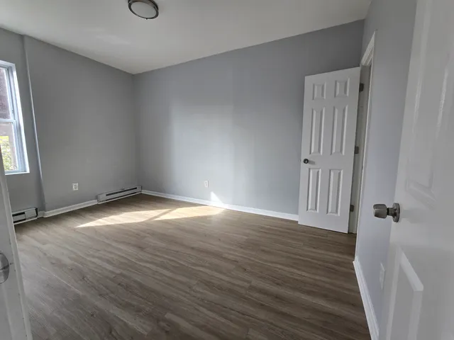 an empty room with wooden floor and a window
